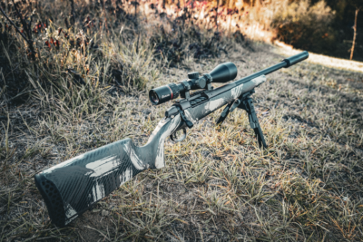 Weatherby Model 307 Alpine CT carbon-fiber hunting rifle with Burris scope mounted on a bipod in an open field during golden-hour light.